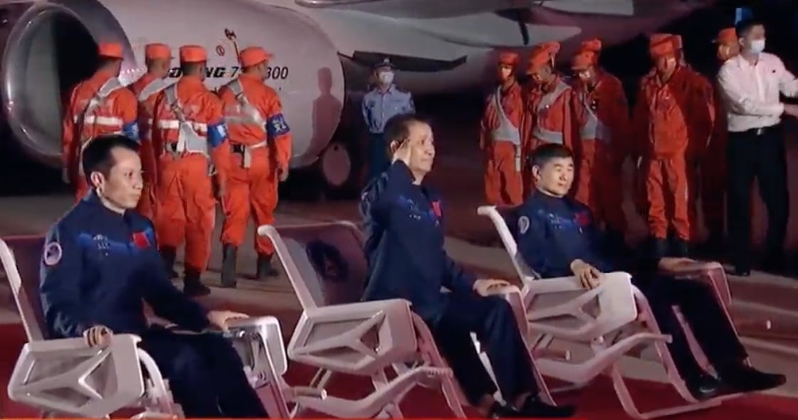 Tang Hongbo, Nie Haisheng et Liu Boming ont été rapatriés sur Pékin en avion peu après leur arrivée. Ici, le commandant Nie Haisheng adresse un salut depuis sa chaise. Après une mission de longue durée comme celle-ci, les astronautes doivent se réhabituer à la pesanteur et sont donc souvent contraints de rester en position assise. Crédit : CNSA/CGTN