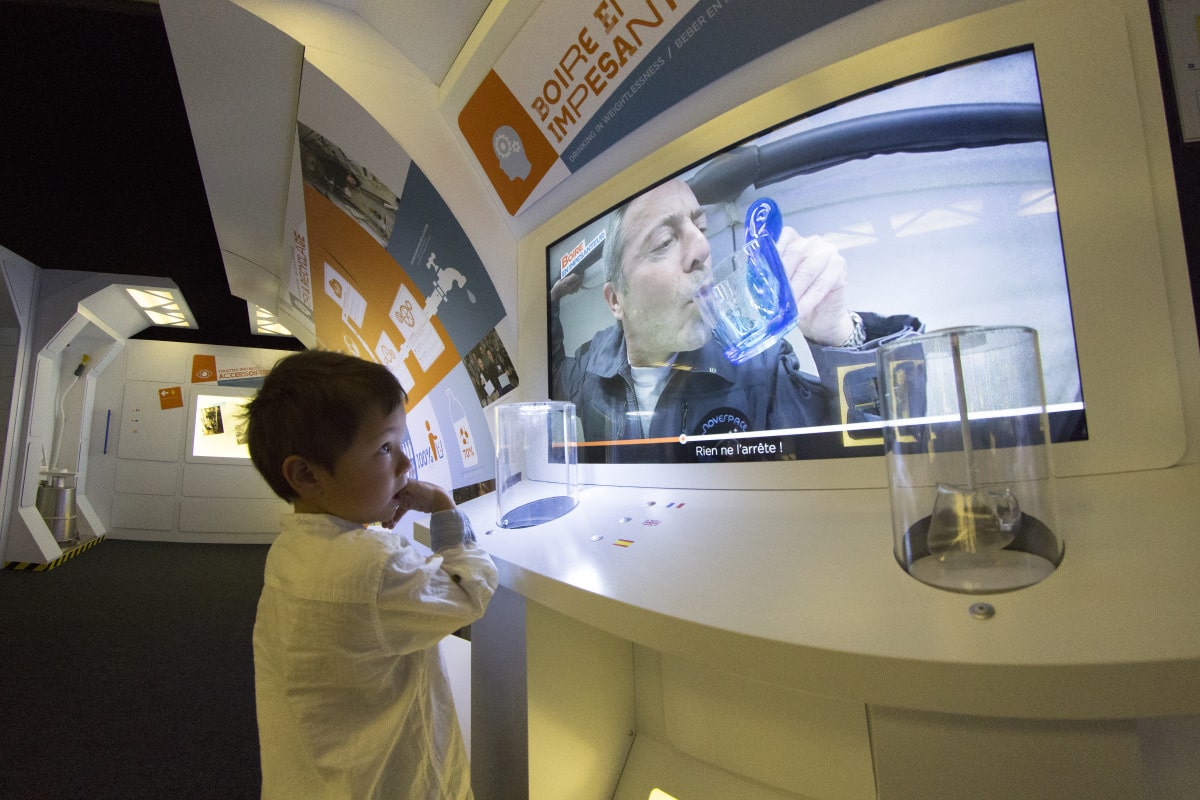 Un enfant regarde la vidéo qui explique comment les astronautes boivent dans l'espace