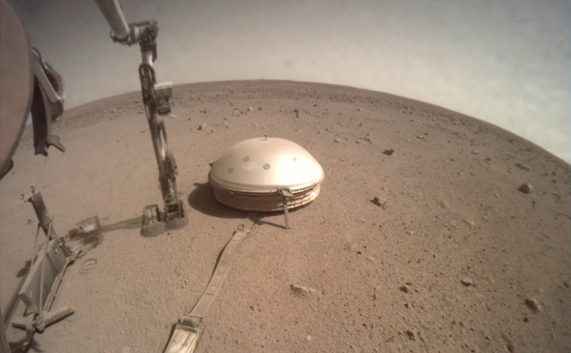 Photographie du sismomètre SEIS. Il a été posé au sol par le bras robotique de l’atterrisseur InSight (immobile, ce n’est pas un rover). Crédit : NASA/JPL-Caltech