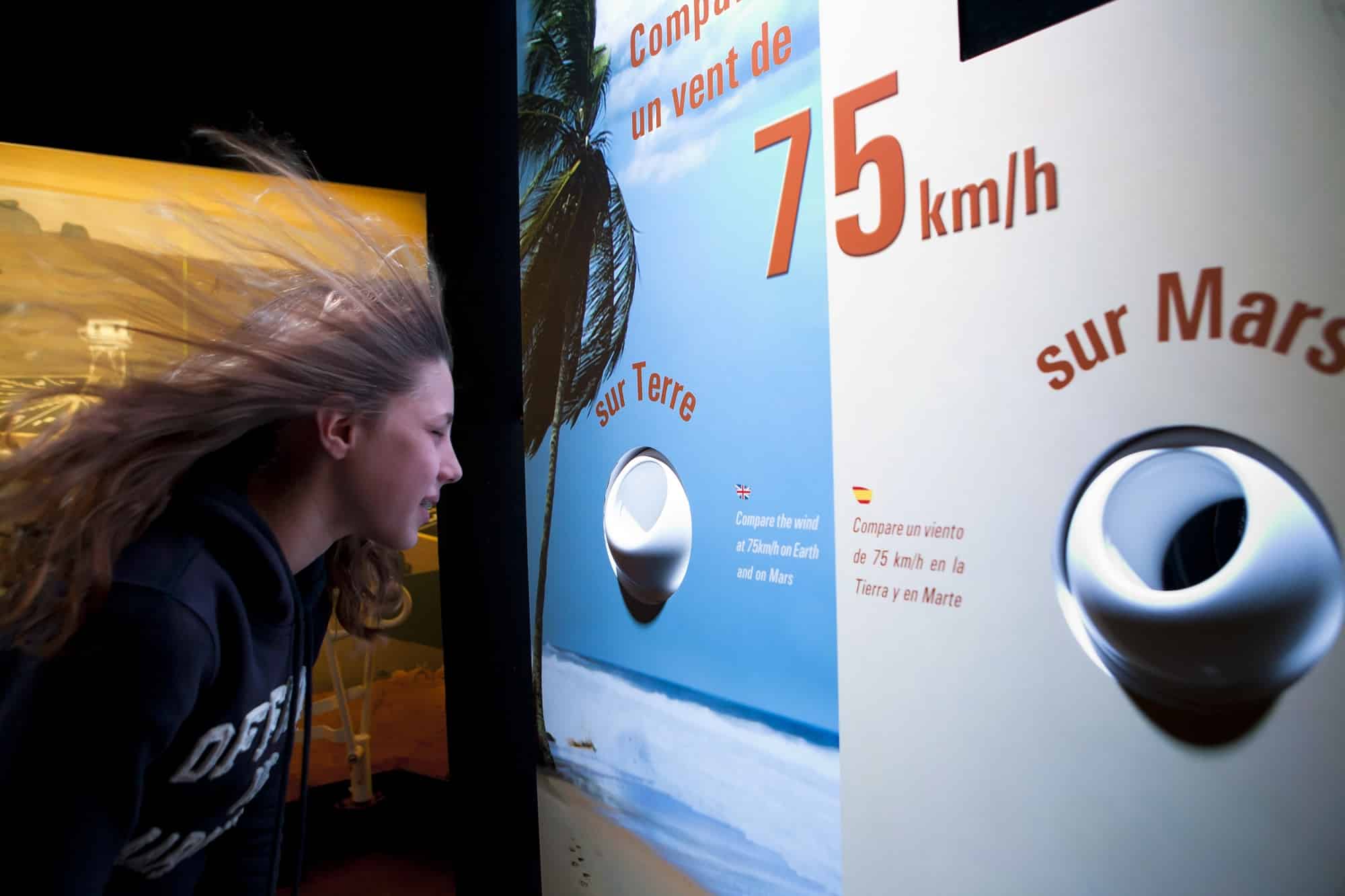 une jeune fille a les cheveux au vent face comparateur de vent